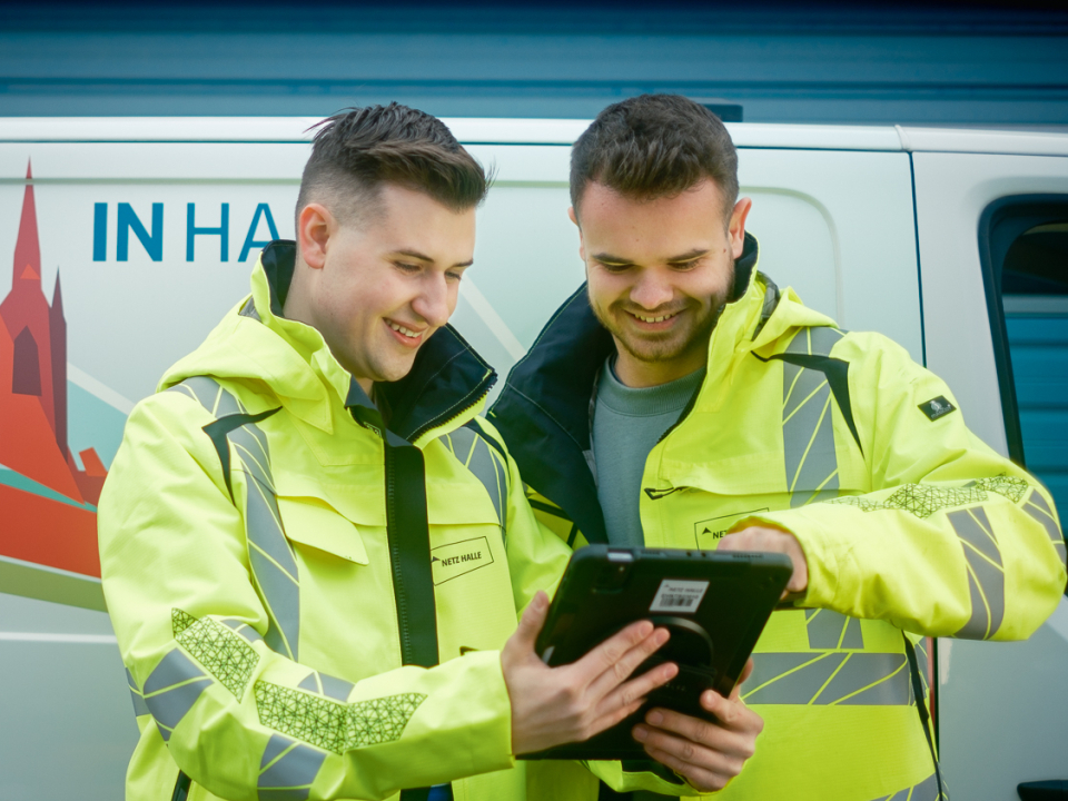 Zwei Außendienstmitarbeiter vor einen Netz Halle Transporter